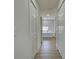 Hallway view of a bright bathroom showcasing marble tile accents and wood-look floors at 307 Big Black Ln, Poinciana, FL 34759