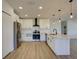 Open-concept kitchen with stainless steel appliances, white cabinets, and a spacious island with modern lighting at 307 Big Black Ln, Poinciana, FL 34759
