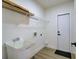 Neat laundry room featuring a utility sink, wire shelving, and door to a service area at 307 Big Black Ln, Poinciana, FL 34759
