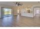 Spacious open-concept living room with vinyl floors, sliding glass door and adjoined kitchen at 307 Big Black Ln, Poinciana, FL 34759