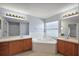 Bathroom with a bathtub, double sink vanity, tile flooring and updated light fixtures at 308 Anorak St, Groveland, FL 34736