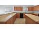 Spacious kitchen featuring ample counter space, wooden cabinetry, and natural light from two large windows at 308 Anorak St, Groveland, FL 34736