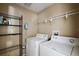 Laundry room equipped with a washer and dryer, shelving, and storage space at 308 Anorak St, Groveland, FL 34736