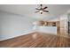 Large living room with laminated flooring, a ceiling fan, and view of kitchen that is perfect for entertaining at 308 Anorak St, Groveland, FL 34736