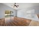 Bright living room with laminated floors, ceiling fan, natural light, and sliding glass door to the patio at 308 Anorak St, Groveland, FL 34736