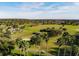 Scenic aerial view of the beautiful green golf course surrounded by palm trees and a residential neighborhood at 3785 Avon Ct, Clermont, FL 34711