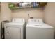 Functional laundry room featuring a washer, dryer, and shelving for convenient storage at 3785 Avon Ct, Clermont, FL 34711