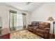 Cozy living room features a comfortable brown recliner, wood flooring, and plenty of natural light at 3785 Avon Ct, Clermont, FL 34711