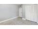 Neutral bedroom features carpeted floors, a spacious closet, and a white door at 3972 Poinsettia Ave, Mount Dora, FL 32757