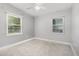 Neutrally painted bedroom featuring carpeted floors and natural light from the two windows at 3972 Poinsettia Ave, Mount Dora, FL 32757