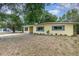 Lovely single-story yellow home with tidy landscaping and mature trees around the property at 3972 Poinsettia Ave, Mount Dora, FL 32757