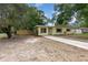 Inviting yellow home with tidy landscaping and a well-maintained front lawn and long driveway at 3972 Poinsettia Ave, Mount Dora, FL 32757