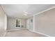 Neutral living area featuring carpeted floors, a ceiling fan, and backyard access at 3972 Poinsettia Ave, Mount Dora, FL 32757