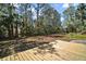 View of the backyard with a wooden deck and heavily wooded area at 40325 Emeralda Island Rd, Leesburg, FL 34788