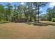 View of the backyard with an outbuilding and the main house in the distance at 40325 Emeralda Island Rd, Leesburg, FL 34788