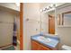 Bathroom vanity features wood cabinets, blue countertop, and a large mirror at 40325 Emeralda Island Rd, Leesburg, FL 34788