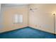 This bedroom has a window, ceiling fan, and neutral walls with bright, blue carpeting at 40325 Emeralda Island Rd, Leesburg, FL 34788