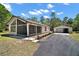 Charming home features a screened porch, two-car detached garage and a long paved driveway at 40325 Emeralda Island Rd, Leesburg, FL 34788