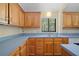 Traditional kitchen with wood cabinets, blue countertops, and stainless steel sink at 40325 Emeralda Island Rd, Leesburg, FL 34788