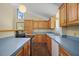 Spacious kitchen with wood cabinets, blue countertops, tile floors, and modern appliances at 40325 Emeralda Island Rd, Leesburg, FL 34788