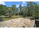 Stone tile patio overlooking a lawn with a view of a treed area at 40325 Emeralda Island Rd, Leesburg, FL 34788