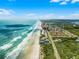 Aerial view showcasing beachfront condos along a beautiful sandy beach at 4435 S Atlantic Ave # 114, Ponce Inlet, FL 32127