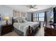 Bedroom with ocean view, ceiling fan, wood-look flooring, and beach-themed decor at 4435 S Atlantic Ave # 114, Ponce Inlet, FL 32127
