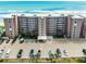 Exterior view of condominium complex with palm trees, parking, and ocean views at 4435 S Atlantic Ave # 114, Ponce Inlet, FL 32127