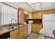 Functional kitchen featuring wood cabinets, tile backsplash, and essential appliances at 4435 S Atlantic Ave # 114, Ponce Inlet, FL 32127