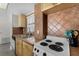 Efficient kitchen with tile counters, wood cabinetry, and a classic electric range at 4435 S Atlantic Ave # 114, Ponce Inlet, FL 32127