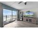 Bright living room with sliding glass door to balcony, ceiling fan, and a serene ocean view at 4435 S Atlantic Ave # 114, Ponce Inlet, FL 32127