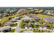Aerial view of a residential area featuring well-maintained lawns and a small pond at 4671 Spring Grove Ln, Leesburg, FL 34748