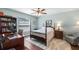 Cozy bedroom features a four-poster bed, a ceiling fan, and a desk, creating a comfortable and functional space at 4671 Spring Grove Ln, Leesburg, FL 34748