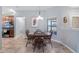Charming dining area features a wooden table, complemented by natural light and an open view to the kitchen at 4671 Spring Grove Ln, Leesburg, FL 34748