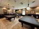 Inviting game room featuring multiple billiard tables under pendant lighting for recreational enjoyment at 4671 Spring Grove Ln, Leesburg, FL 34748