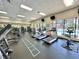 Fully-equipped gym with modern cardio machines, weight training equipment, and a view of the outdoor pool at 4671 Spring Grove Ln, Leesburg, FL 34748