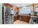 Well-lit kitchen features stainless steel appliances, brown cabinets, and granite countertops for a modern and functional space at 4671 Spring Grove Ln, Leesburg, FL 34748