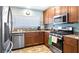 Well-lit kitchen features stainless steel appliances, brown cabinets, and granite countertops for a modern and functional space at 4671 Spring Grove Ln, Leesburg, FL 34748