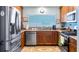 Well-lit kitchen features stainless steel appliances, brown cabinets, and granite countertops for a modern and functional space at 4671 Spring Grove Ln, Leesburg, FL 34748