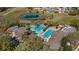 Aerial view of a uniquely shaped community pool, lap pool, and clubhouse near a pond at 4671 Spring Grove Ln, Leesburg, FL 34748