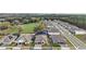 Areal view of the residence within a residential neighborhood surrounded by green spaces and mature trees at 488 Avila Pl, Howey In The Hills, FL 34737