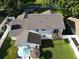 Aerial view of the backyard with deck, lush green lawn, and patio under the umbrella at 4941 Tradition Dr, Lakeland, FL 33812