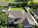 Aerial view showcasing home's manicured lawn, white fence, and a pond view, enhancing its appeal at 4941 Tradition Dr, Lakeland, FL 33812