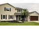 Charming two-story home featuring a well-manicured lawn, complemented by a side-entry garage and stone accents at 4941 Tradition Dr, Lakeland, FL 33812