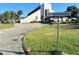 Community building entrance with American flags along the driveway leading up to Hawthorne Blvd sign at 504 Hawthorne Blvd, Leesburg, FL 34748