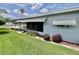 This home features light blue siding, awning, landscaping, and a cozy screened-in porch at 504 Hawthorne Blvd, Leesburg, FL 34748