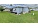 Well-maintained home featuring light blue siding, awning and lush green lawn and landscaping at 504 Hawthorne Blvd, Leesburg, FL 34748
