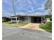 Charming single-story home with well-maintained landscaping and a covered carport on a sunny day at 504 Hawthorne Blvd, Leesburg, FL 34748