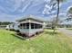The house exterior shows beautiful flower beds and large windows for natural lighting at 504 Hawthorne Blvd, Leesburg, FL 34748