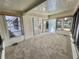 Enclosed Florida room with lots of natural light, screened windows, carpet flooring, and outside access at 504 Hawthorne Blvd, Leesburg, FL 34748